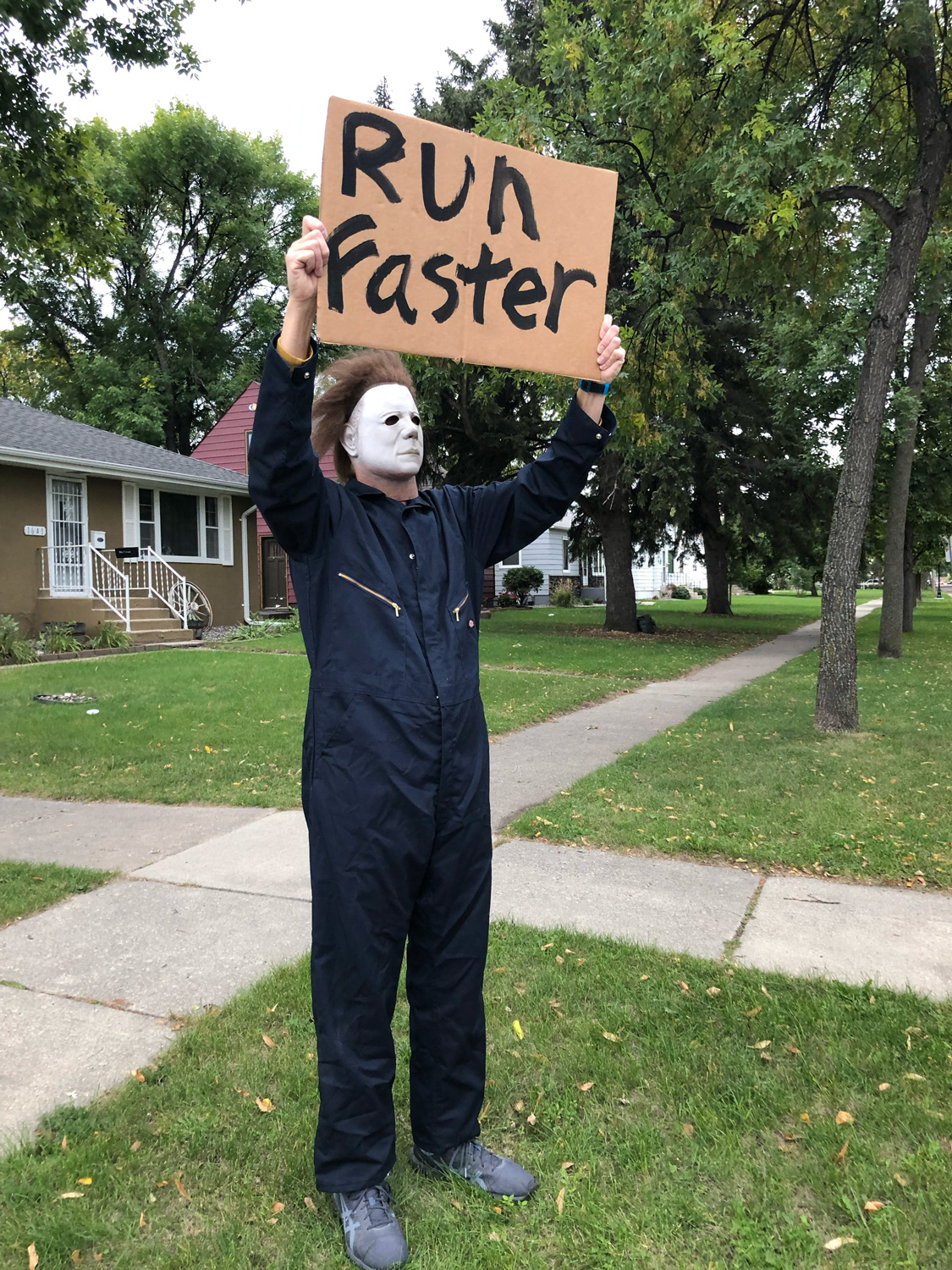Michael Myers holding a "Run Faster" sign