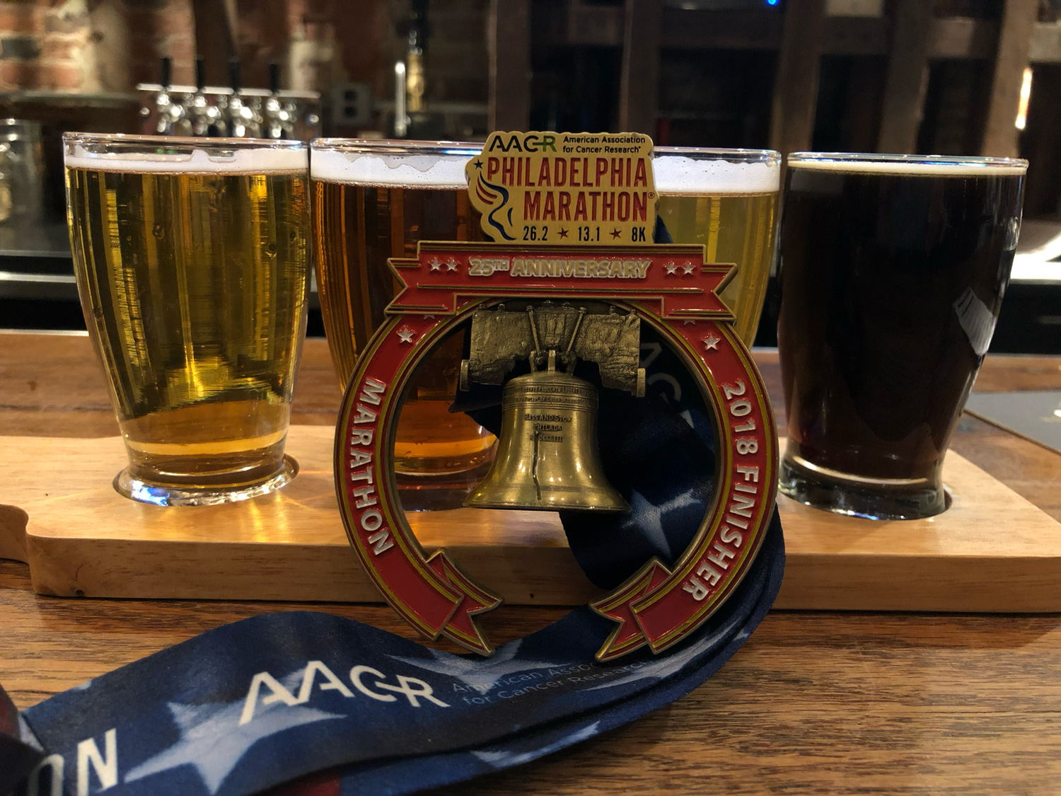 Marathon medal against a flight of beer