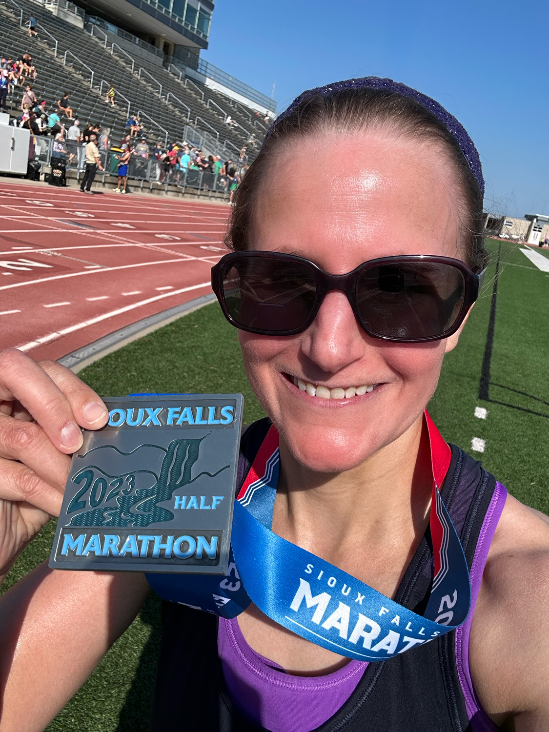 Me at the finish with my 2023 Sioux Falls Half Marathon medal