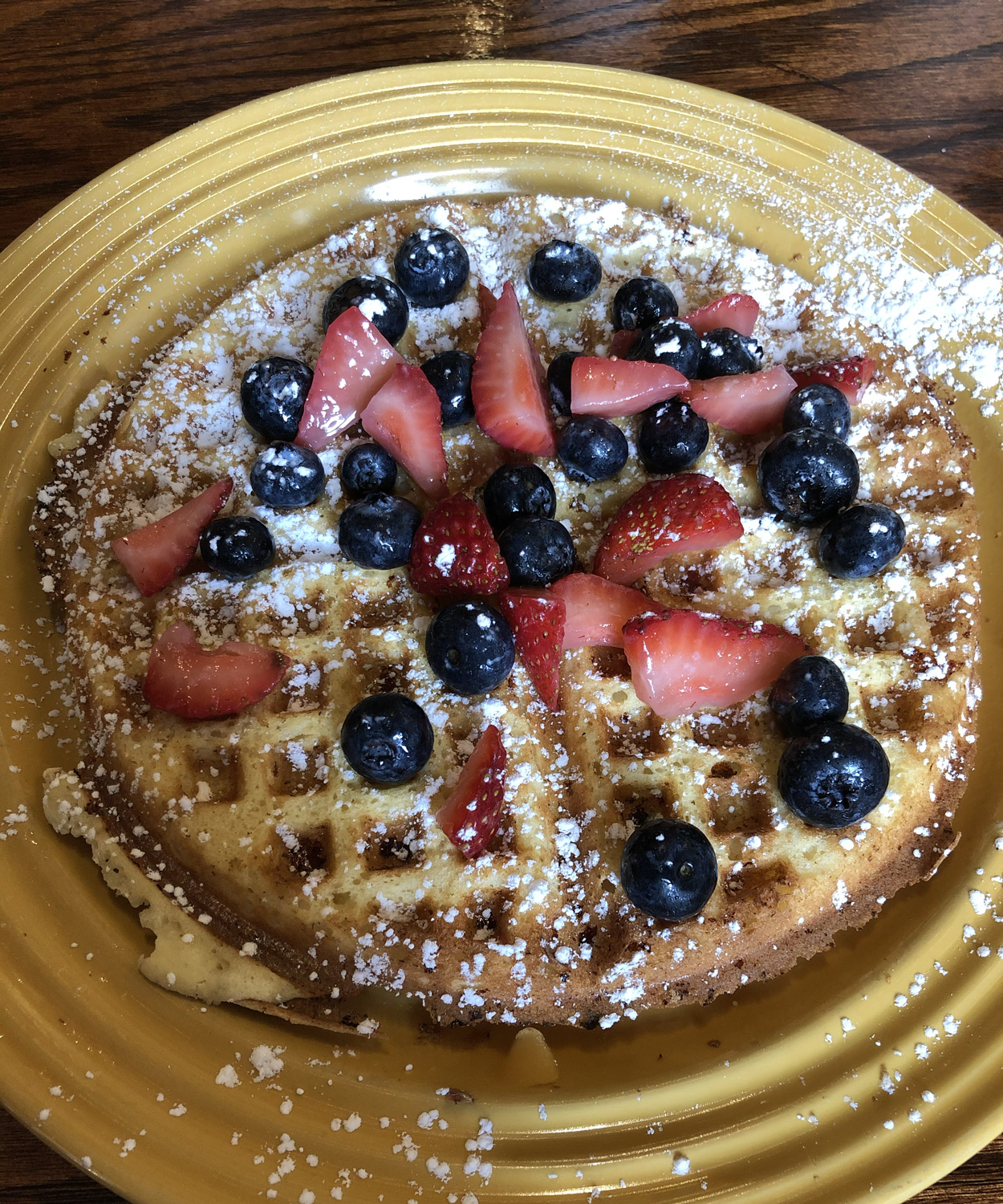 A syrupy waffle with strawberries and blueberries, yum